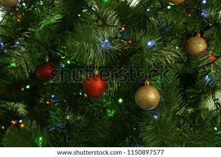 Fir tree with festive decor and glowing Christmas lights as background