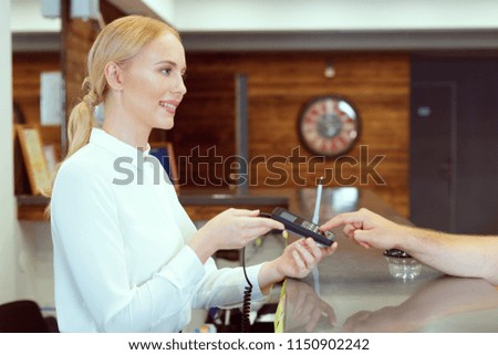Guest at hotel reception paying with check during check-in