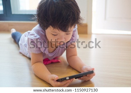 asian chinese girl playing smartphone on bed, watching smartphone, kid use phone and play game, child use mobile, addicted game and cartoon
