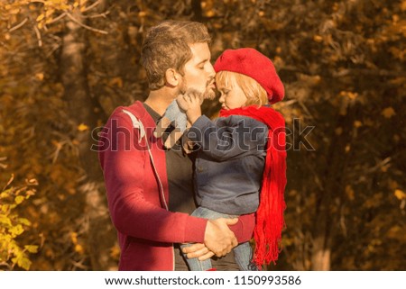 Happy autumn. Dad kissing daughter on forehead.