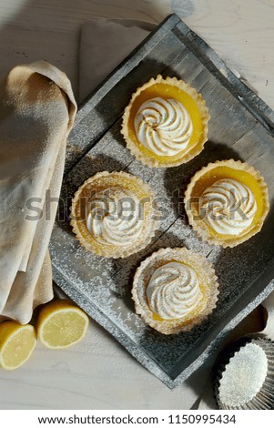 Delicious lemon tartlets with meringue on a white vintage plate.