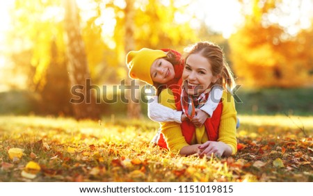 happy family mother and child daughter playing and laughing on   autumn walk 
