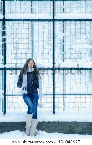 Young girl in a snow park. Walk in the winter season. Walking a lonely girl in the winter