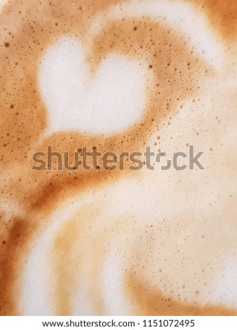 Drawing of the heart symbol from barista on the surface of a cappuccino