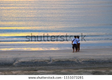 Men and women are taking a picture of the blue sea and the shine of the sun reflecting on the sea.view in the evening.At Ao Manao, Prachuap Khiri Khan Province. 