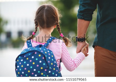 first day at school. father leads a little child school girl in first grade
 Royalty-Free Stock Photo #1151079065
