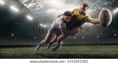 Two male Rugby players fight for the ball in flight on professional rugby stadium Royalty-Free Stock Photo #1151091581