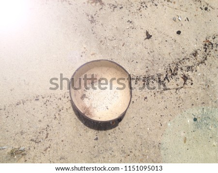 COCONUT SHELL ON A BEACH WITH  DIRTY SAND AND FLARES