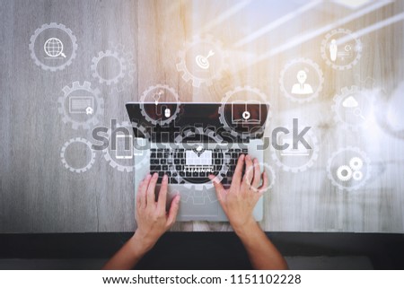 E-learning with connected gear cogs connected diagram virtual dashboard.top view of Designer hand working with laptop computer on wooden desk as responsive web design concept Royalty-Free Stock Photo #1151102228