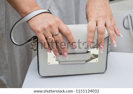 Beautiful manicure, women's hands, handbag

