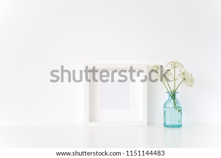 Minimal white square frame mock up with a Aegopodium in transparent blue vase. Mockup for quote, promotion, headline, design. Template for small businesses, lifestyle bloggers, social media