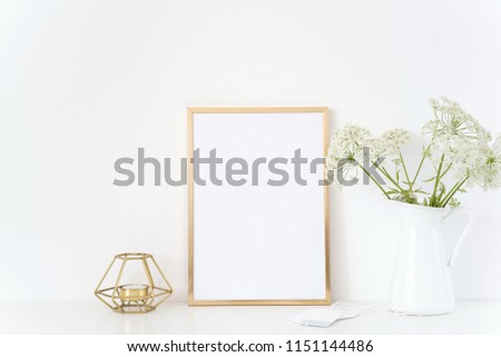 Gold frame mock up with a wild host in jug and candle. Mockup for headline design.Template for lifestyle bloggers,media