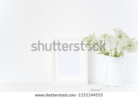 Elegant white frame mock up with a host in jug, bouquet. Mockup for design.Template for lifestyle bloggers, social media