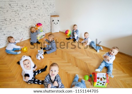 Baby boy all around, playing at home. Multiple babies clone concept. Nine babies in playroom, crawling and playing ball, busy mom concept. Multiple photos merged, natural lighting.