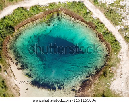 The spring of the Cetina River (izvor Cetine) in the foothills of the Dinara Mountain is named Blue Eye (Modro oko). Cristal clear waters emerge on the surface from a more than 100 meter-deep cave. Royalty-Free Stock Photo #1151153006