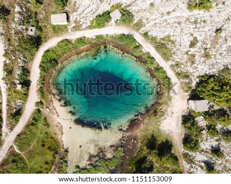 The spring of the Cetina River (izvor Cetine) in the foothills of the Dinara Mountain is named Blue Eye (Modro oko). Cristal clear waters emerge on the surface from a more than 100 meter-deep cave. Royalty-Free Stock Photo #1151153009