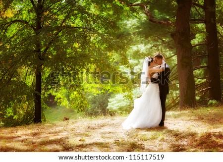Wedding shot of bride and groom in park Royalty-Free Stock Photo #115117519