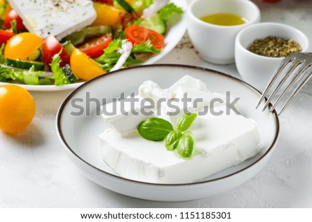 Tatsy fresh Greek feta cheese in a bowl whole and slices for salad with vegetables