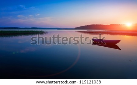 Sunrise over the lake. The first rays of sun. Royalty-Free Stock Photo #115121038