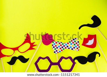 Top view image of  funny masks beard, glasses, mustache,lips ,smoking pipe and bow on yellow background. Party, birthday, Halloween Father day, Purim, Fool day concept. 