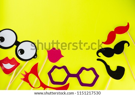 Top view image of  funny masks beard, glasses, mustache,lips, smoking pipe  on yellow background. Party, birthday, Halloween Father day, Purim, Fool day concept. 