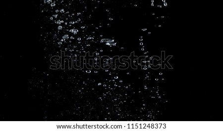 Close-up images of soda water splashing in the water to many little bubbles that make it feel like refreshing and black background 