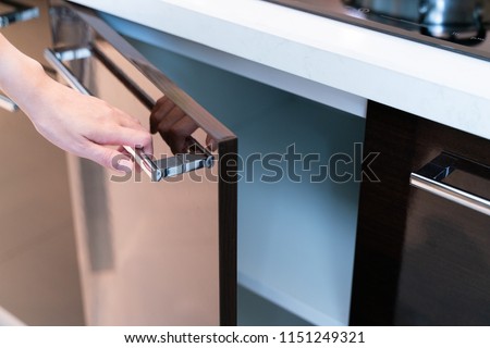 hand Open Kitchen Cabinet Royalty-Free Stock Photo #1151249321