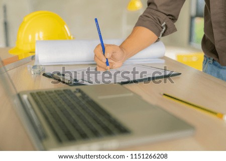 civil architect engineer choose color of building with laptop,engineering and architecture concept.Blue print is fake only for stock photo.