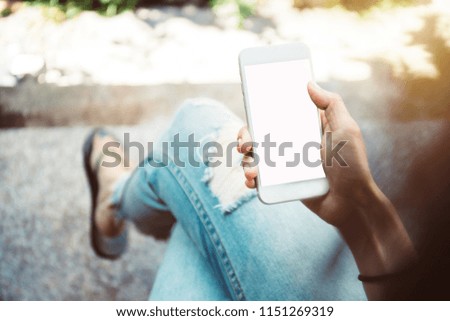 mock up.selective focus.hand women holding and using mobile phone with copy space,blank screen for text.concept for business,people communication,technology electronic device.modern life style