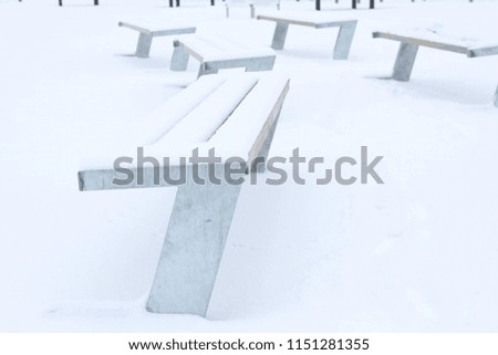 Bench in winter park covered with snow. Winter in the City. Winter bench - Stock image
