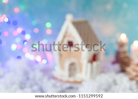 Blurred image of gingerbread house and gingerbread trees on a festive Christmas background