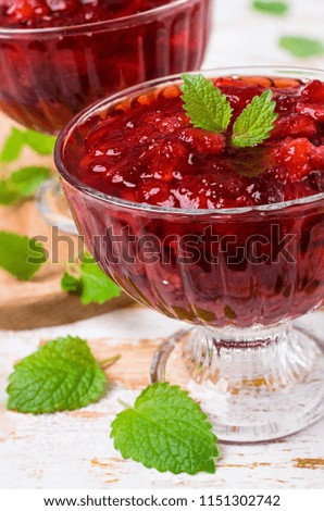 Sliced red strawberries in a thick sweet syrup. Selective focus.