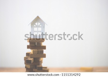 Model white house on wood block. Investment risk and uncertainty in the real estate housing market. Property investment and house mortgage financial concept. with copy space for your text.