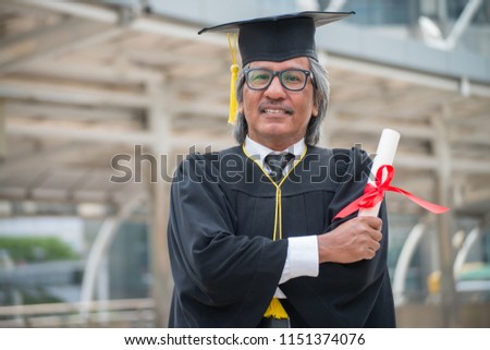 Portrait photo of happy senior graduated university student after received certificated diploma. Education and elder people concept.