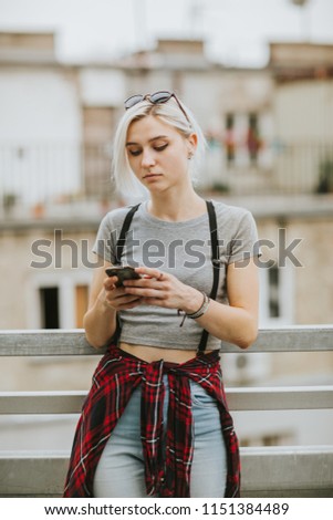 Young hipster woman using mobile phone