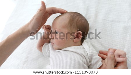 Mother stroking the child to feel the fontanel of 1 months baby girl Royalty-Free Stock Photo #1151398073