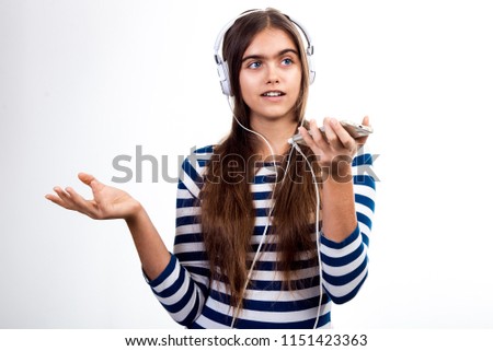 young beautiful girl speaks by mobile phone. Girl with headphones and mobile phone.  student talks to her friend. modern Teenager on a white background