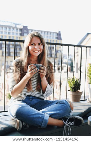 Young beautiful woman sitting at hipster coffee place on roof top, taking city view selfie pictures on mobile cellphone. Female making self portraits via smartphone. Close up, copy space, background.