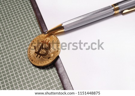 Bitcoin with a pen on paper background
