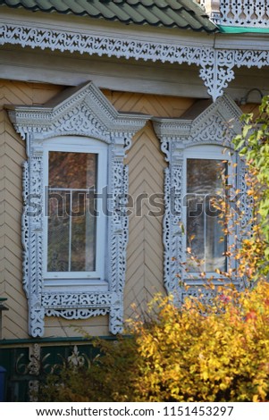 Richly decorated ornamental carved windows, frames on vintage wooden rural house in Myshkin town, Yaroslavl region, Russia. Russian traditional national folk style in wooden architecture. Countryside