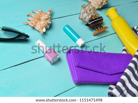 Beach bag and accessories for relaxing on the beach layout on blue wooden background. The concept of the resort at sea, summer time. Top view, flat lay, minimalism
