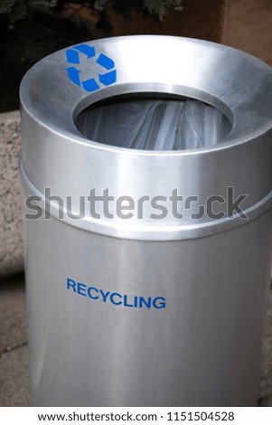 Close up on an aluminum recycling bin with space for text on top and bottom