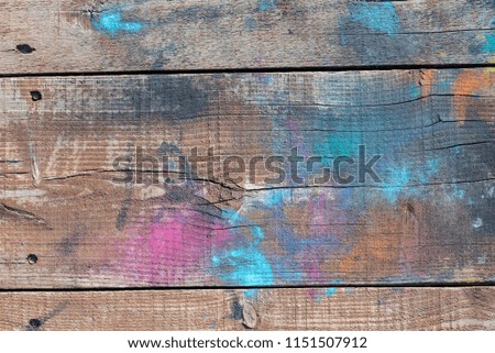 Old weathered dark brown wood on a wooden wall made from pine wood with knots, with traces of different colors paint on a surface