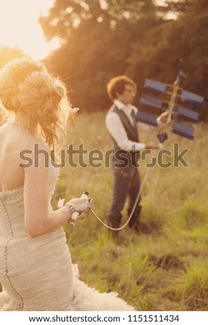 Bride and groom playing with a kite in the sunset