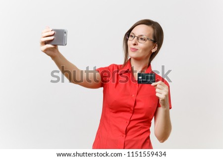 Excited business woman in red shirt doing taking selfie shot on mobile phone with credit bank card, cashless money isolated on white background. Education teaching in high school university concept