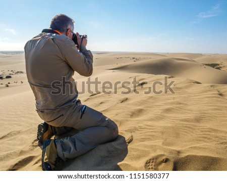 Man taking pictures to the desert