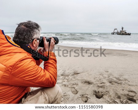 Man taking pictures to a shipwreck