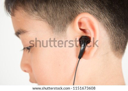 Close up ear's boy use earphone listen the music from the phone