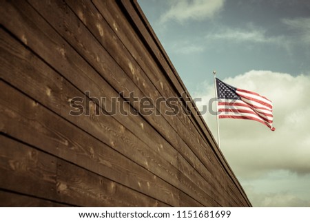 Border wall with American flag flying over head tightened security in the United States
