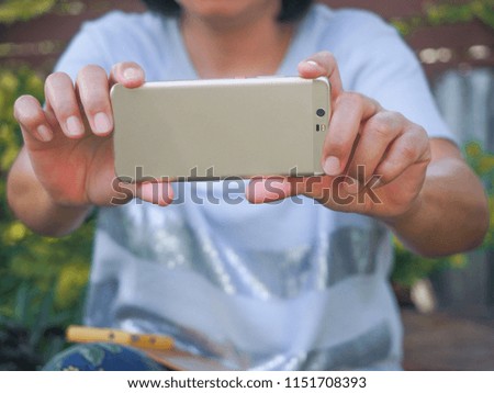A lady is taking picture and video with smart phone